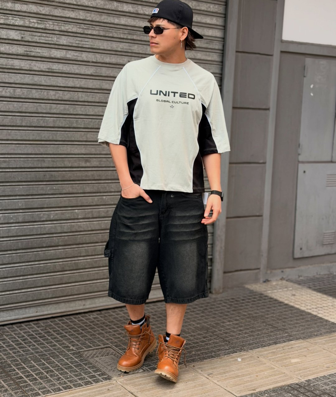 Remera boxy United gris claro con paneles negros, usada con bermuda de jean negra