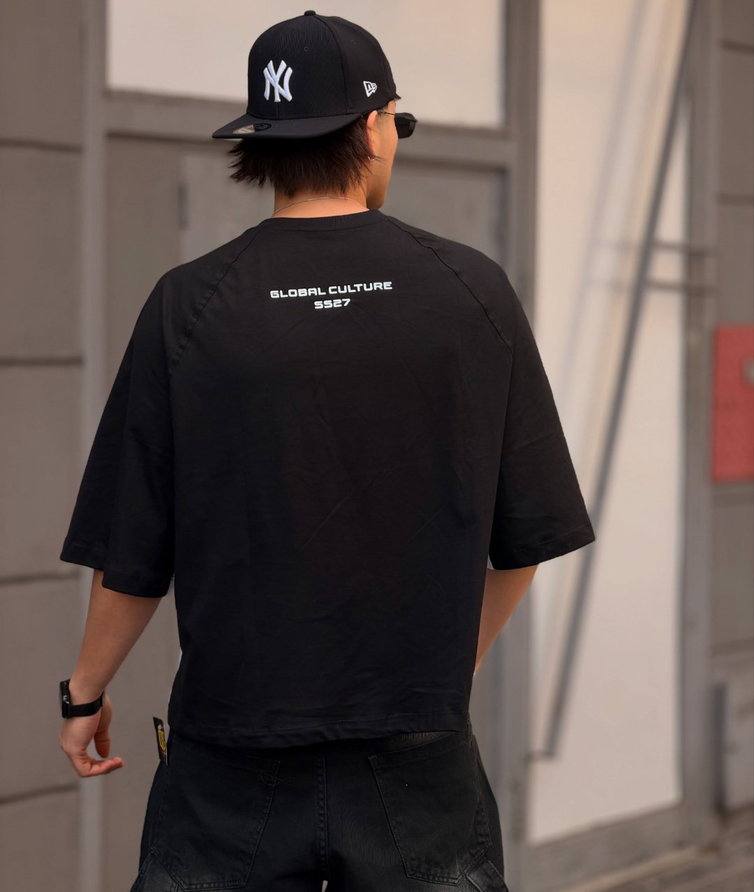 Espalda de la remera negra con estampa Global Culture SS27 en blanco